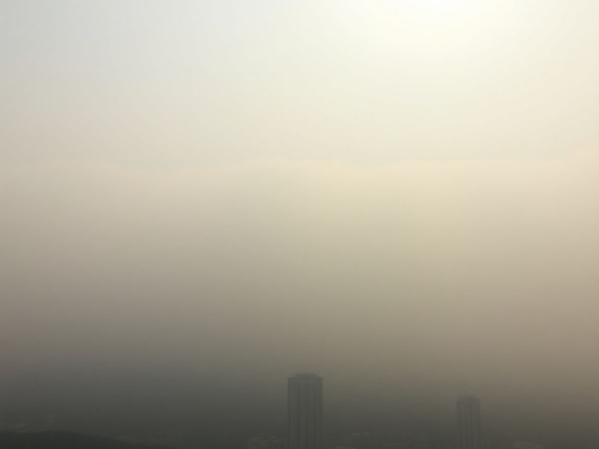Oraș sufocat de smog, cu clădiri în ceață toxică.